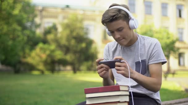 Teen Boy Sluchátka Hrají Mobilní Hru Místo Domácích Úkolů Otálení — Stock video