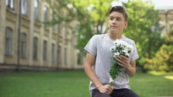 兴奋的少年男孩与花束的鲜花等待女朋友 — 图库视频影像