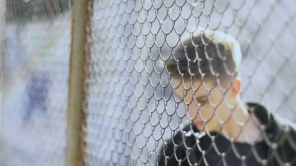 Bereaved Adolescente Levanta Contra Rejilla Metal Refugio Mira Con Ojos — Vídeos de Stock
