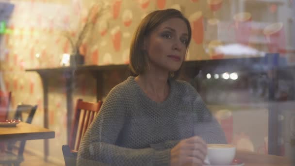 Задумчивая Женщина Смотрит Прохожих Через Окно Своей Любимой Кофейни — стоковое видео