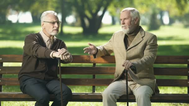 加齢に伴うアルツハイマー病 公園で話している古くからの友人に苦しんでいる年配の男性 — ストック動画