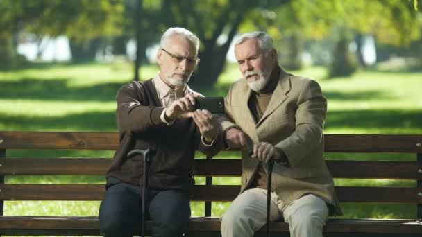 Two Senior Males Sitting Park Talking Friend Web Camera Phone — 图库视频影像