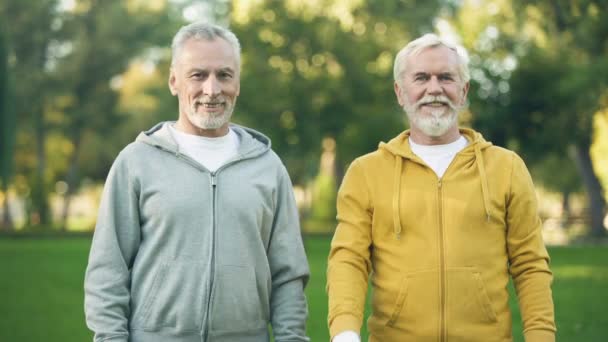 Två Leende Äldre Män Sportkläder Visar Tummen Upp Hälsosam Livsstil — Stockvideo