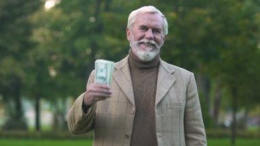 Dolar faturaları, finansal başarı iş kar tutan şık erkek gülümseyen