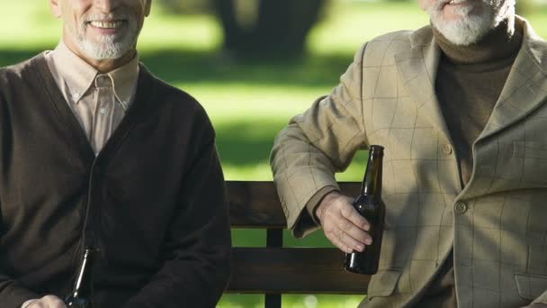 Hombres Ancianos Sonrientes Mostrando Botellas Cerveza Sentados Banco Bebidas Alcohólicas — Vídeo de stock