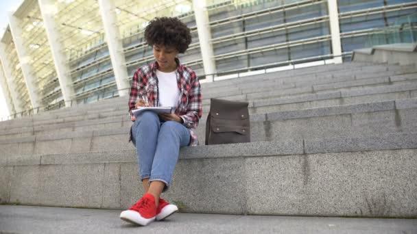 Linda Estudiante Pelo Rizado Haciendo Tarea Sentado Las Escaleras Cerca — Vídeos de Stock