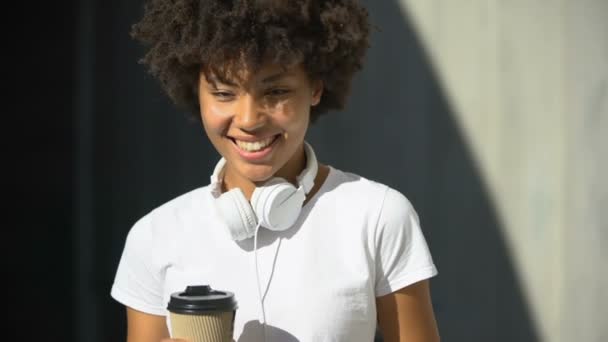 Despreocupada Afro Americana Hembra Sosteniendo Taza Sonriendo Cámara Coquetear — Vídeos de Stock