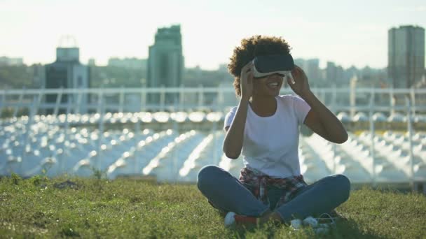 Funny Curly Haired Female Using Headset Sitting Lawn Sunny Day — Stock Video