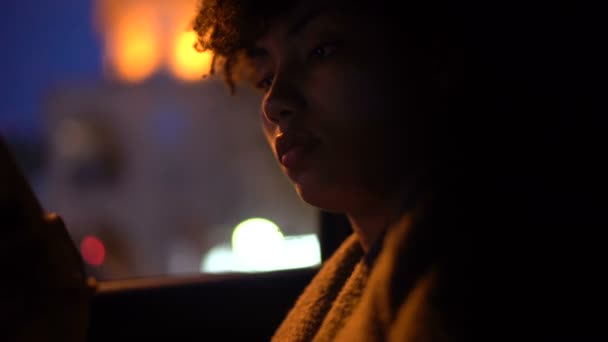 卷发女士坐在出租车上 看着手机 夜间驾驶 特写镜头 — 图库视频影像