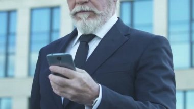 Cep telefonuyla mutlu üst düzey iş adamı başarılı anlaşma hakkında mesaj okuma