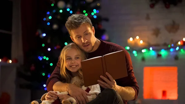 Уважний Батько Читає Різдвяну Казку Щасливої Дівчини Біля Прикрашеного Дерева — стокове фото