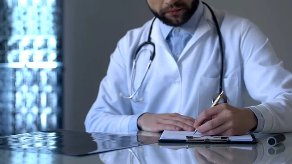 Experienced Traumatologist Looking Leg Ray Making Notes Medical Form — Stock Photo, Image