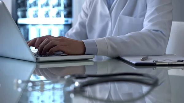 专业医生在网上病历中填写数据 在笔记本电脑上工作 — 图库照片