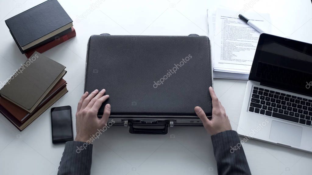 Manager with brief case sitting on work place, business ethics in big company