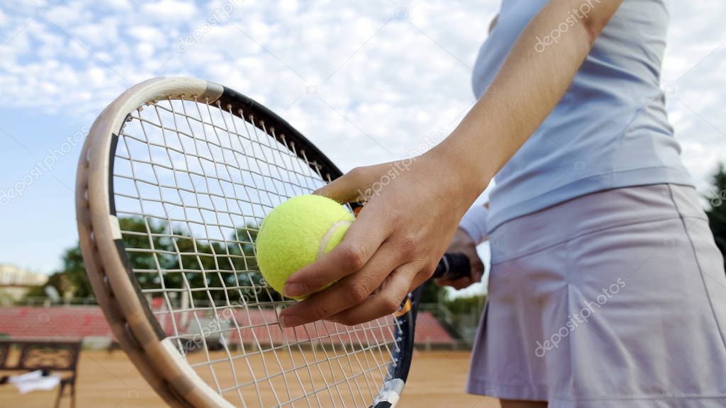 Bottom view of beautiful woman serving tennis ball, professional sport, hobby