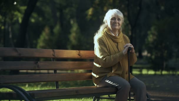 悲伤孤独的老太婆坐在公园的长椅上 独自抛弃老人 — 图库视频影像