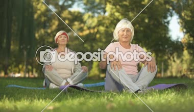 Yaşlı kadın Lotus pozisyonda oturan ve meditasyon yoga Park, enerji yaparken