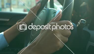 Hands of business woman holding steering wheel, driving vehicle, traffic jam