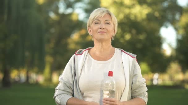 Middelbare Leeftijd Vrouw Weergegeven Fles Water Duimen Omhoog Gezonde Levensstijl — Stockvideo