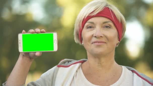 Sonriente Forma Mujer Mediana Edad Que Muestra Pantalla Verde Del — Vídeo de stock