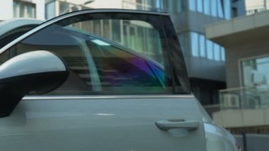 Confident business lady getting out of auto turns on car alarm successful person