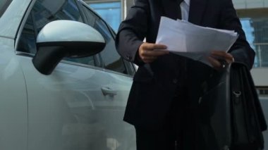 Erkek patron Smartphone cep telefonu ile aracın, yanında iş sorunları çözme belgeleri holding