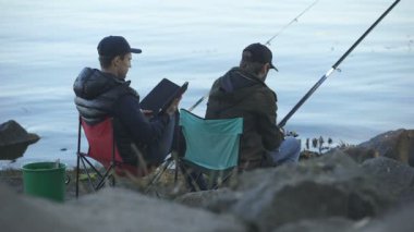 Öğreticiler balıkçılık web sitelerinde arama için sıkılmış erkek balık, yakalama kullanarak tablet