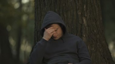 Park, işsizlik sorunu, zorluklar ağacın altında oturan depresif adam