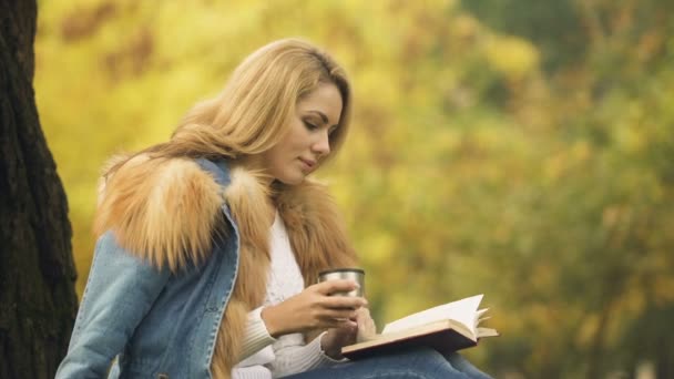 本を読んで 孤独ながら魔法瓶カップから地球温暖化飲料を飲む女性 — ストック動画