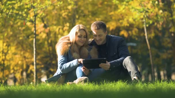 Casal Compras Line Usando Tablet Parque Outono Comprando Roupas Quentes — Vídeo de Stock