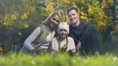 Geleneksel aile piknik gülümseyen ve kameraya, sigorta seyir Park üzerinde