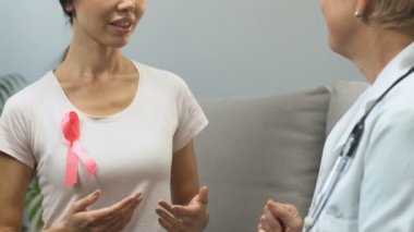 Kadın doktor muayenesi, meme kanseri bilinçlendirme, önleme, pembe kurdele ile