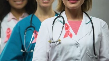 Kamera için poz pembe kurdeleler ile kadın hekimler, meme kanseri farkındalık
