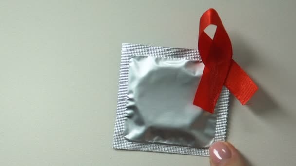 女性は赤いリボン 安全なセックスのヒント エイズの予防にコンドームを置くヘルスケア — ストック動画