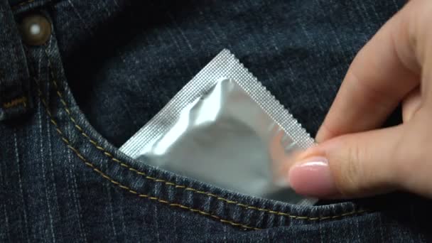 女手将避孕套放在裤子里 避孕和预防疾病 — 图库视频影像