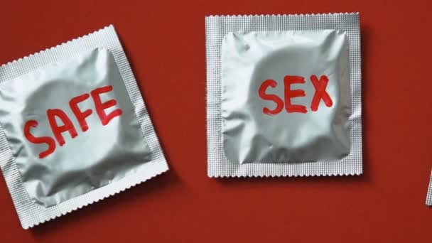 避孕套与安全性词在红色背景 帮助的概念时尚的警觉性 — 图库视频影像