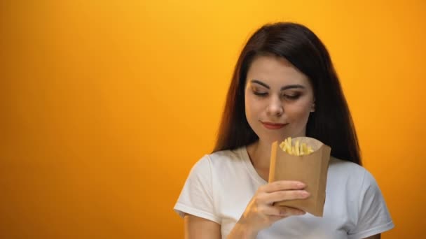 Menina Sorridente Mostrando Batatas Fritas Para Câmera Recomendando Comida Rápida — Vídeo de Stock