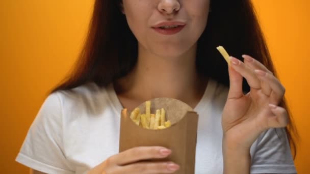 フライド ポテト 人工的な味と強化された味 中毒を食べて幸せな女の子 — ストック動画