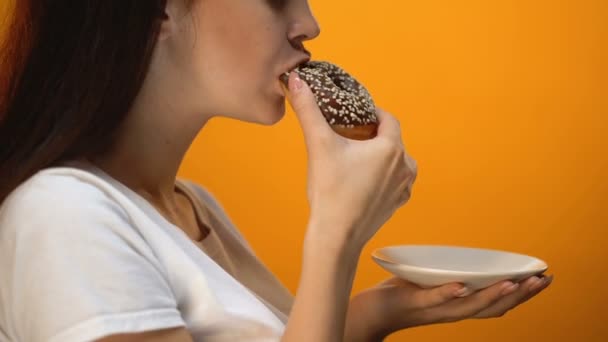 Девочка Кусающая Шоколадный Пончик Высококалорийная Сладкая Еда Повышенный Диабет Глюкозы — стоковое видео