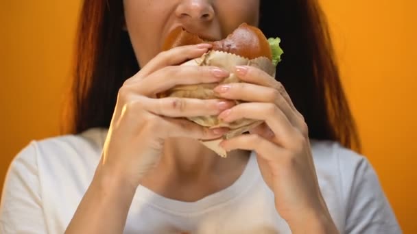 まずいハンバーガー 食品の品質 クローズ アップに不満をかむ女性 — ストック動画