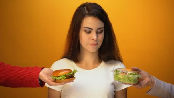 Красива Жінка Вибирає Салат Замість Гамбургера Охорона Здоров Нездорове Харчування — стокове відео