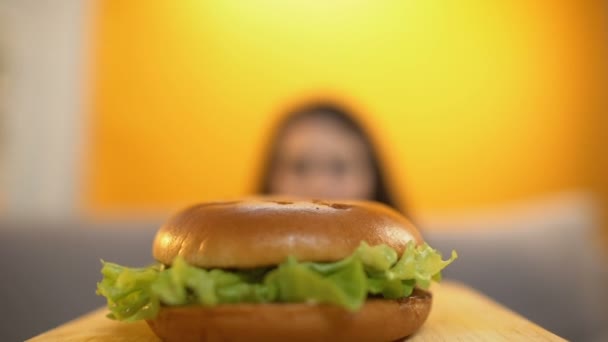 人服务汉堡饥饿的女孩 妇女吃以贪婪和胃口 — 图库视频影像