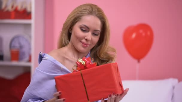 Όμορφη Κυρία Αγκάλιασμα Κόκκινη Συσκευασία Δώρου Και Χαμογελά Στη Φωτογραφική — Αρχείο Βίντεο