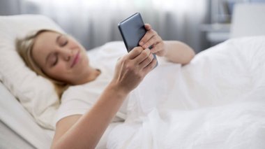 Sörf için internet Smartphone kullanarak selfie sabah alarak mutlu genç kız