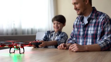 Neşeli çocuk ve babası evde quadcopter, boş zaman, aygıt faaliyet