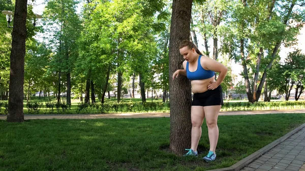 Feta Tjejen Trött Efter Jogging Lutad Mot Trädet Tröttsamt Träning — Stockfoto