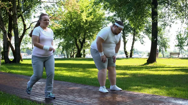 Joyful Gordinha Menina Ultrapassando Obeso Homem Cansado Após Jogging Exercícios — Fotografia de Stock