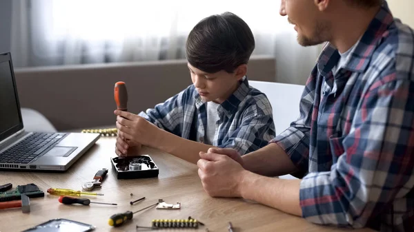 父亲教他可爱的小儿子修理硬盘驱动器在家里 — 图库照片