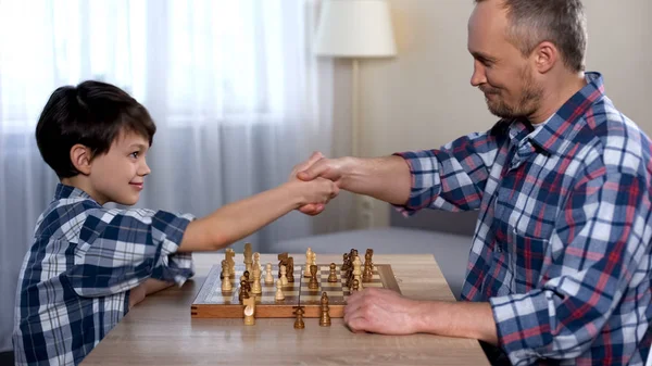 Male Kid Winning Chess His Father Little Son Shaking Hand — Stock Photo, Image