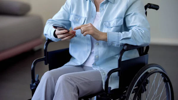 スマート フォン 通信でインターネットの閲覧の車椅子女性年金受給者 — ストック写真